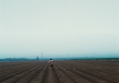 running scene from the master 2012, the vast sky contrastic the rapid movement of quell running on the empty cabbage field (gif by cinecat on tumblr)